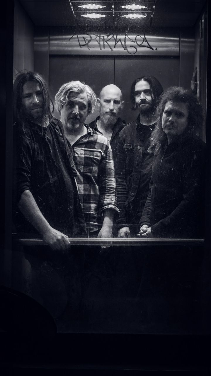 The five members of Band of Phantoms standing in a graffiti-tagged lift, looking straight at the camera