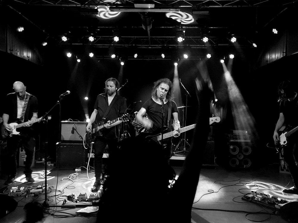 Wide shot of the band under stage lights at Chemiefabrik
