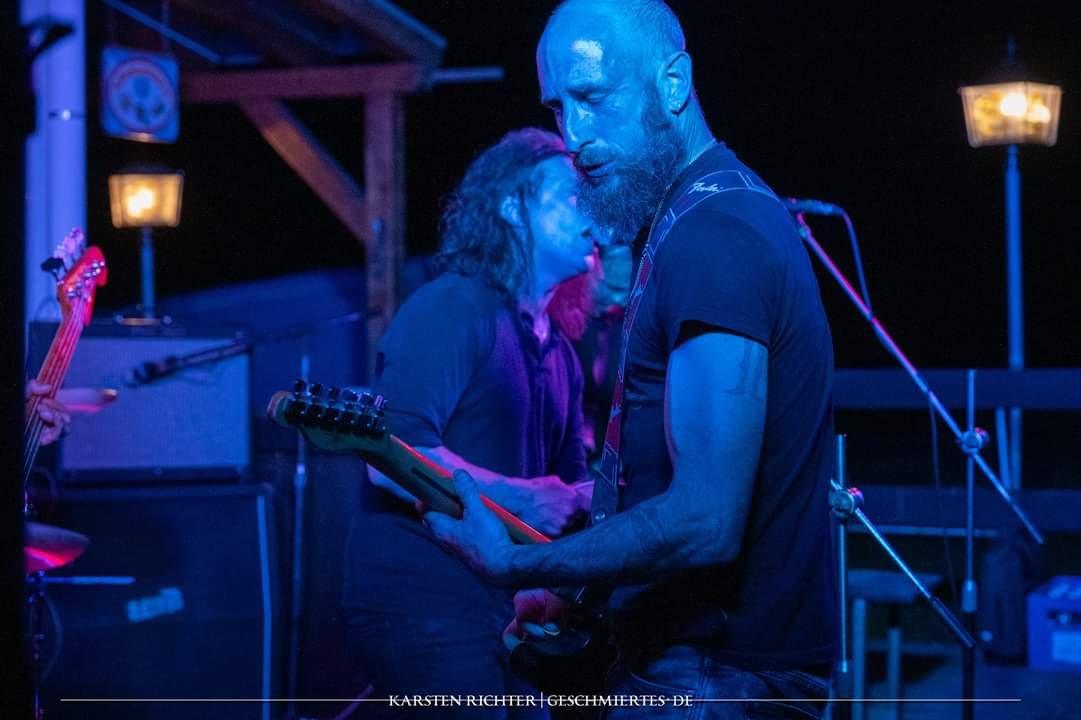 Guitarists on a blue-lit stage at Desert Wood festival