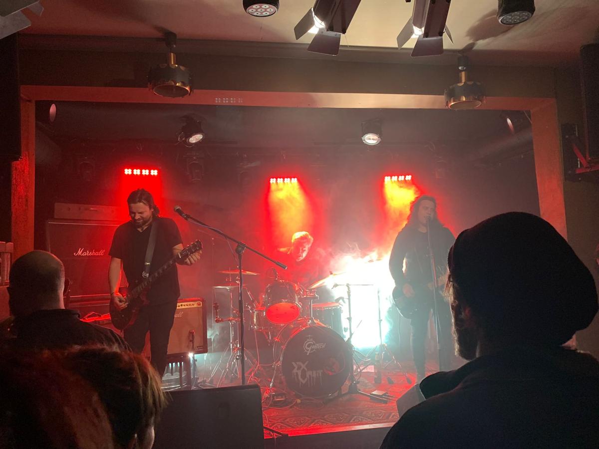 Band on stage under red lights at Ostpol